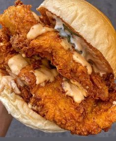 a fried chicken sandwich is being held up