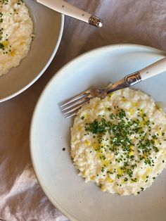 two white plates topped with mashed potatoes and garnished with chives