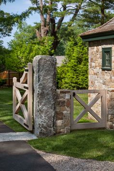 a stone building with a wooden gate in front of it and grass on the ground