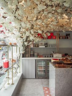 the interior of a bakery with cherry blossoms on the ceiling