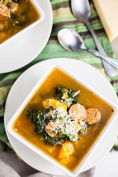 two white bowls filled with soup on top of a table