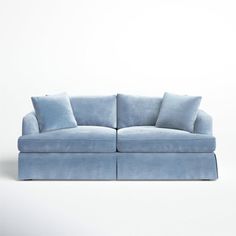 a blue couch with two pillows on the back and one arm folded out to form a rectangle shape