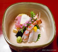 there is a small bowl filled with different types of sushi and other food items