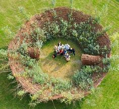 an aerial view of people standing in the middle of a circle made out of trees