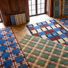 three different colored rugs on the floor in a room with wood paneled walls