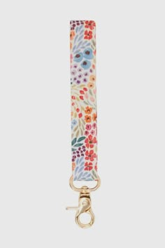 the floral strap is attached to a gold metal hook and has an adjustable clip on it