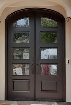 the front door to a house with two large doors and glass panels on each side