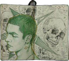 an open book with drawings and skulls on the pages, including a drawing of a man's head