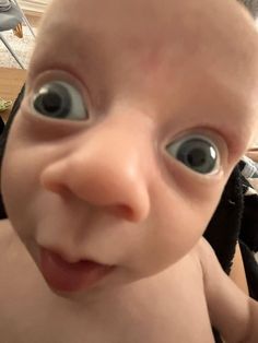 a close up of a baby with big eyes