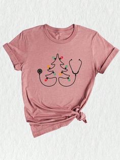 a pink t - shirt with a stethoscope on the chest and christmas trees drawn on it