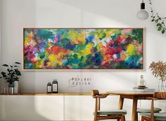 a painting hanging on the wall above a dining room table