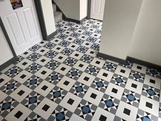 a tiled floor with blue and white designs on the bottom, and black and white floors