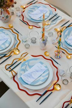 the table is set with blue and white plates, silverware, and napkins