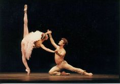 two ballerinas are performing on stage with one holding the other's leg