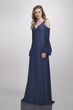 a woman in a long blue dress with an open shoulder and lace detailing on the sleeves