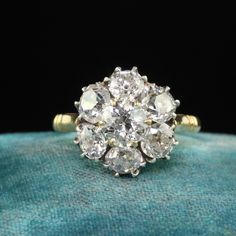 an antique diamond cluster ring on a velvet cushion