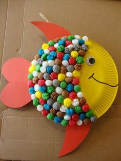 a paper plate that has some kind of fish made out of cereal and candy on it