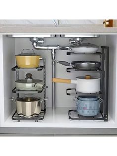 an open cabinet with pots and pans in it