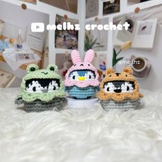 three small crocheted animals sitting on top of a bed