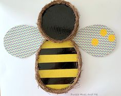 a paper plate with a bee in the center and two circles on each side that have been cut out to look like bees