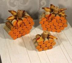 two wine corks are arranged in the shape of pumpkins with leaves on them