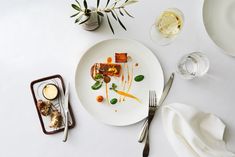 a white plate topped with food on top of a table next to utensils