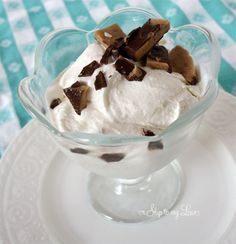 a glass bowl filled with ice cream and chocolate chips on top of a white plate