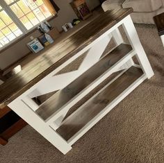 a white table sitting on top of a carpeted floor next to a couch in a living room