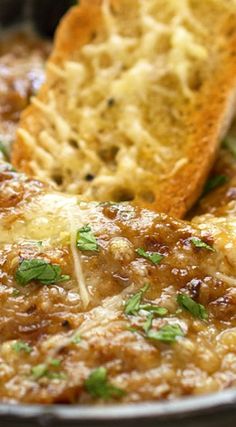 a close up of food in a pan with bread on the side and parsley