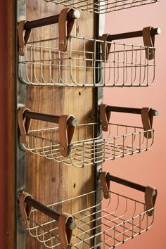 a wall mounted metal shelf with several hooks on the bottom and one hanging from it's sides