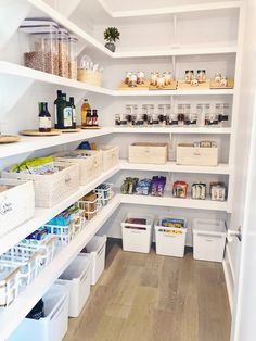 an organized pantry with white bins and baskets