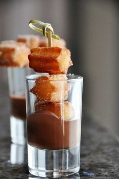 two glasses filled with food sitting on top of a counter