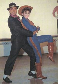 a man and woman dressed in western style clothing, one holding the other's leg