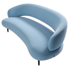 a blue curved couch sitting on top of a white floor