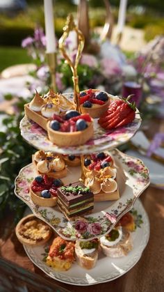 three tiered trays filled with cakes and pastries on top of each other