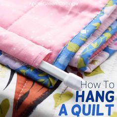 an image of how to hang quilts on the bed with text overlay that reads, how to hang a quilt