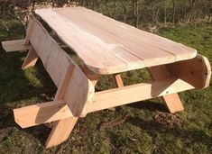 a wooden picnic table sitting in the grass