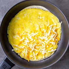 an omelet with cheese is cooking in a pan