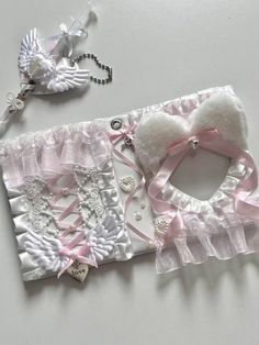 two pieces of white and pink fabric with angel decorations