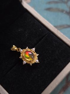 This exquisite fire opal pendant features a stunning gemstone that radiates vibrant hues of orange, red, and yellow, capturing the essence of a fiery sunset. Set in an intricately designed vintage-style gold plated setting, the pendant evokes the charm and elegance of a bygone era. The ornate detailing of the setting enhances the opal's natural beauty, while the unique cut of the stone ensures maximum brilliance. Perfect for adding a touch of timeless sophistication to any outfit, this fire opal Fiery Sunset, Fire Opal Jewelry, Fire Opals Jewelry, Fire Opal Necklace, Bygone Era, Opal Pendants, Red And Yellow, Opal Necklace, Opal Jewelry