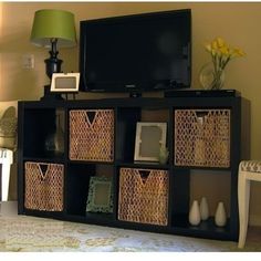 an entertainment center with wicker baskets on the bottom and blue arrows pointing to it