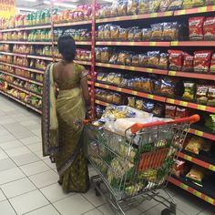 a woman pushing a shopping cart in a grocery store