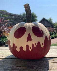 a painted pumpkin sitting on top of a wooden table