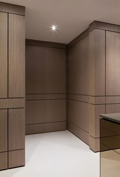 an empty room with wooden walls and cabinets