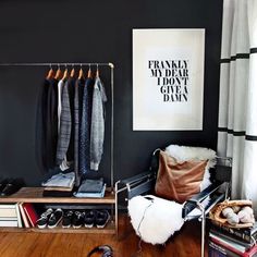 an organized closet with clothes hanging on the rack and other items in front of it