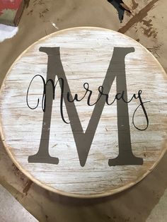 a wooden sign with the word merry written in black ink on it, sitting on top of a piece of wood