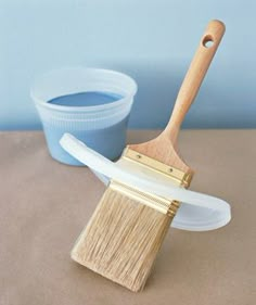 a paint brush and container sitting on a table