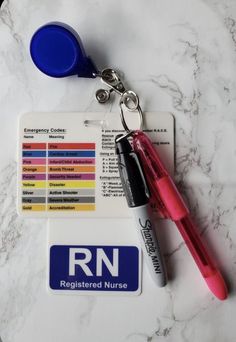 a key chain with a pen, marker and identification card attached to it on a marble surface