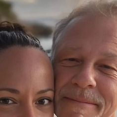 an older man and young woman are smiling for the camera while standing close to each other