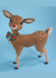 a stuffed deer with a bell around its neck on a blue background and wearing a bow